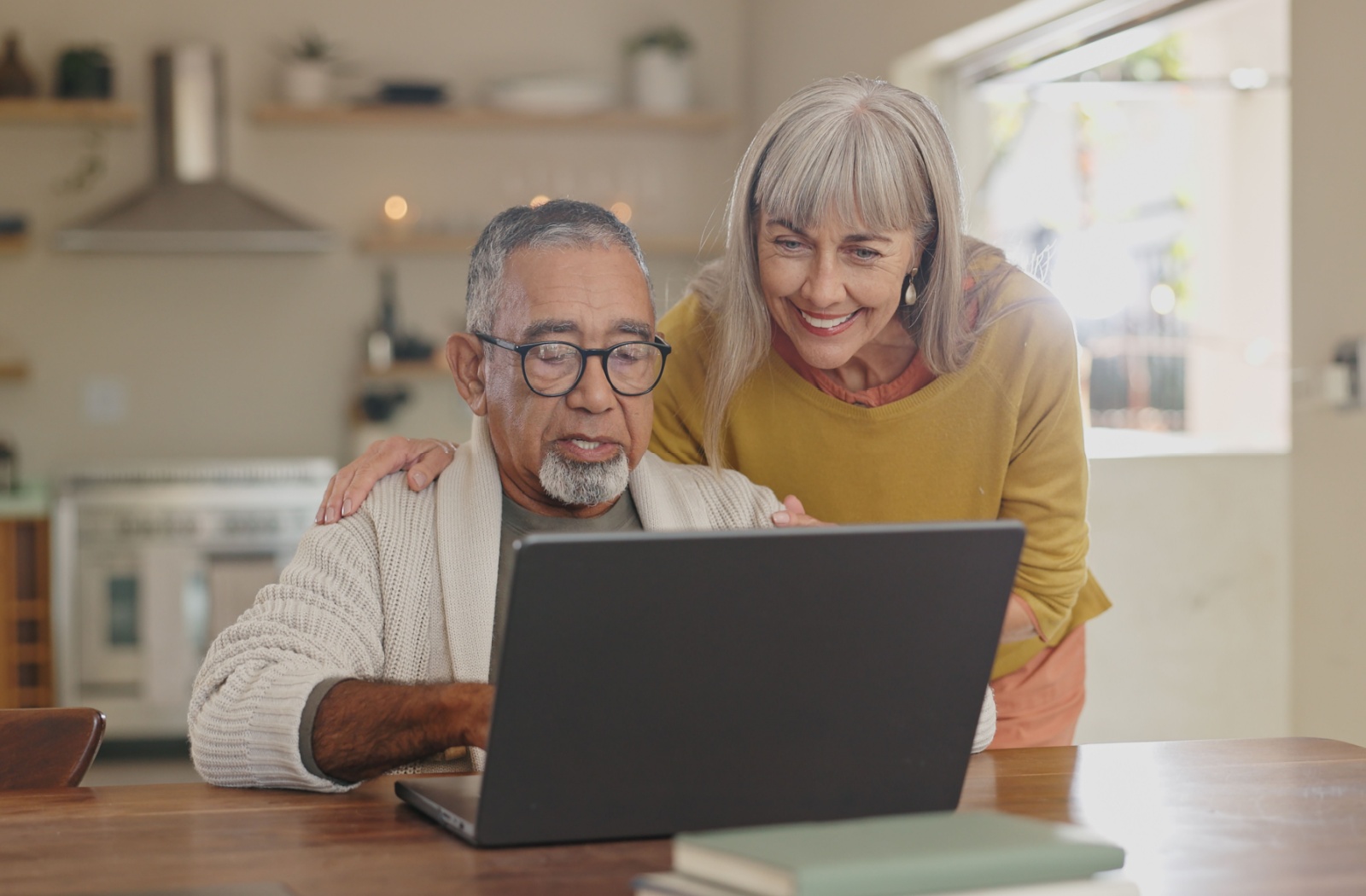 A couple of seniors look at conveniently-located senior living communities on their computer.