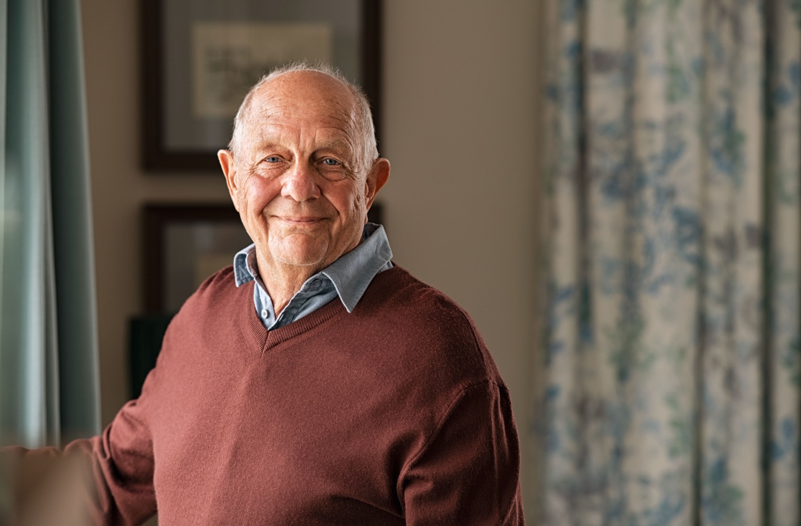 A senior man smiling and looking directly at the camera